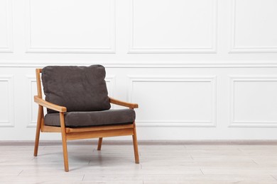 Photo of Comfortable soft armchair near white wall, space for text