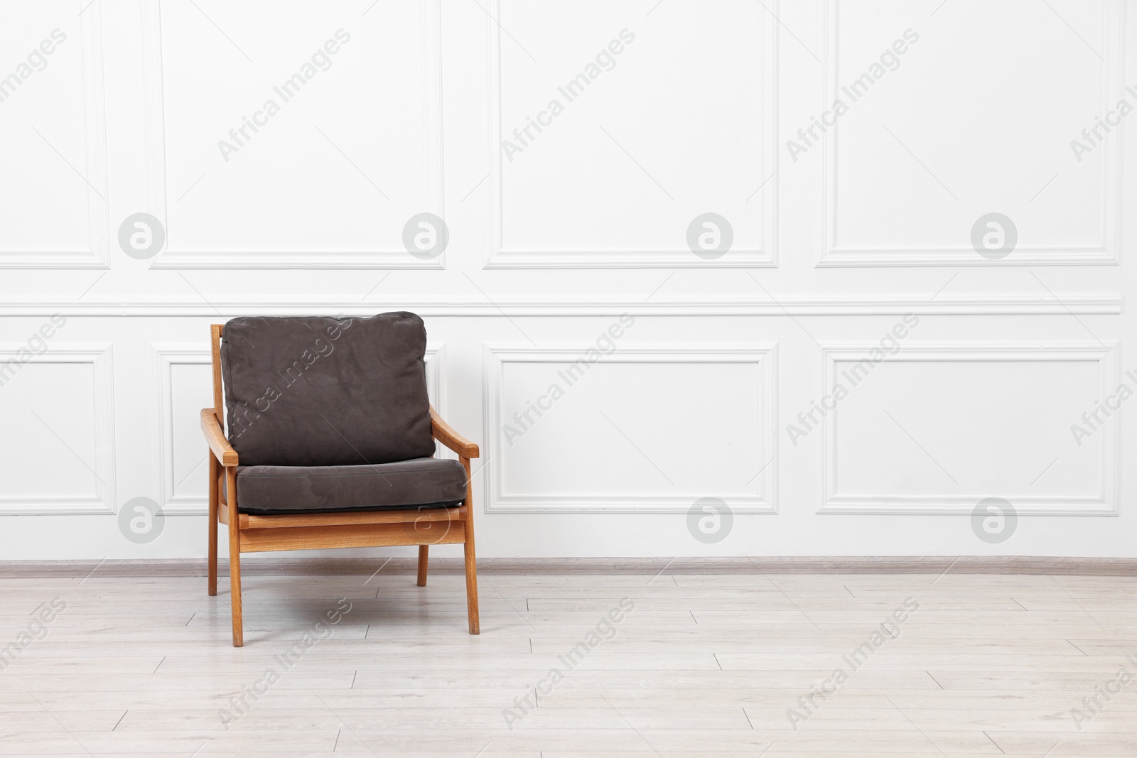 Photo of Comfortable soft armchair near white wall, space for text