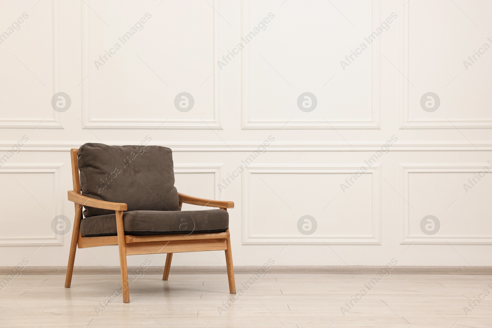 Photo of Comfortable soft armchair near white wall, space for text