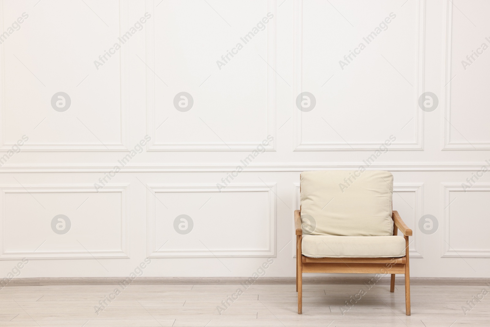 Photo of Comfortable soft armchair near white wall, space for text