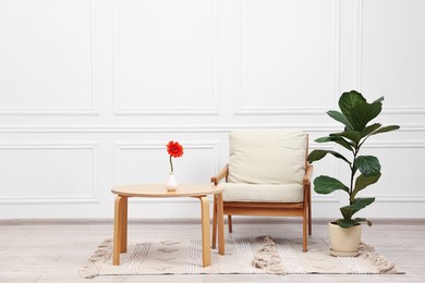 Photo of Beautiful interior with comfortable armchair and coffee table