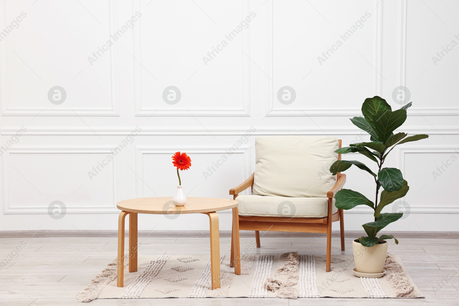 Photo of Beautiful interior with comfortable armchair and coffee table