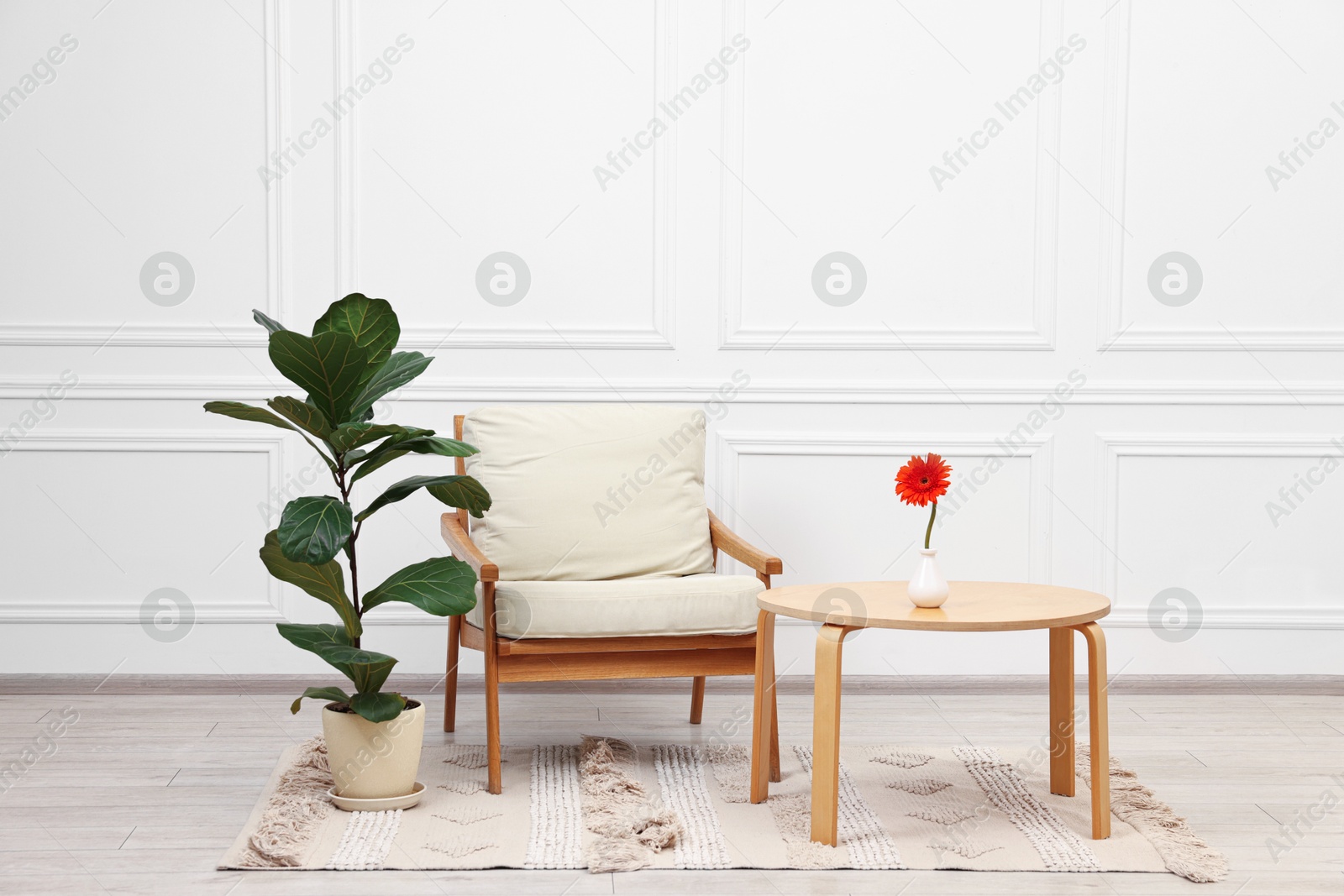 Photo of Beautiful interior with comfortable armchair and coffee table