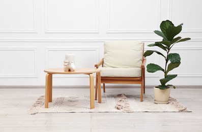 Photo of Beautiful interior with comfortable armchair and coffee table