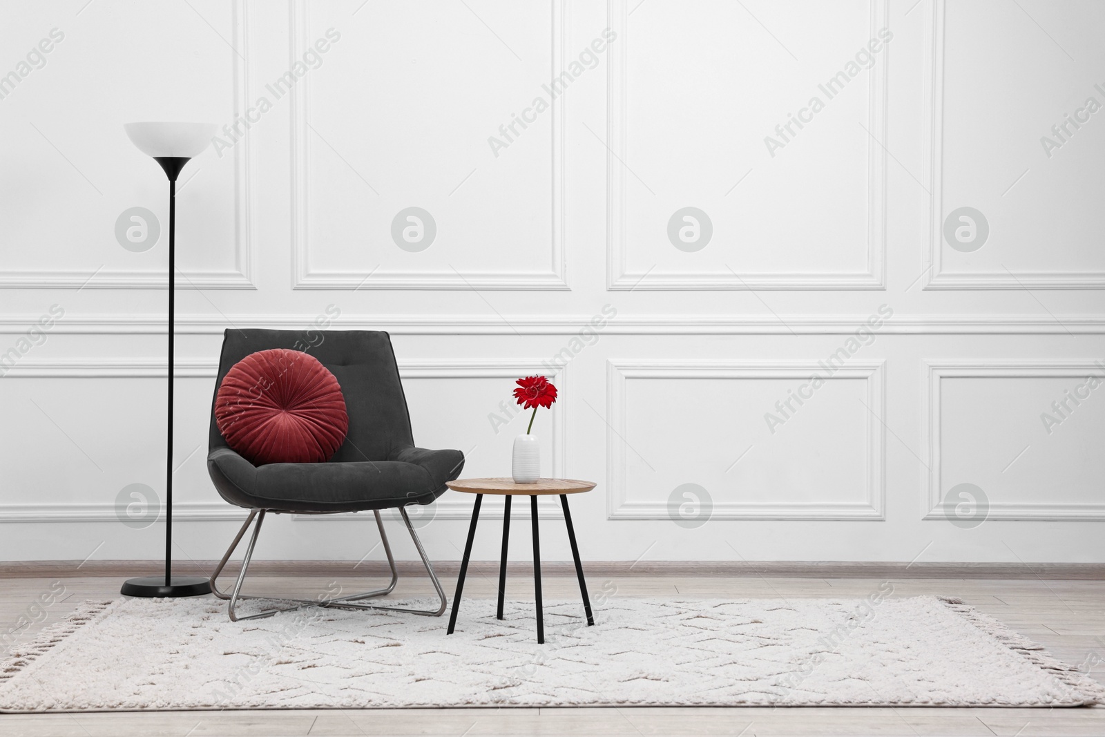 Photo of Beautiful interior with comfortable armchair and floor lamp, space for text