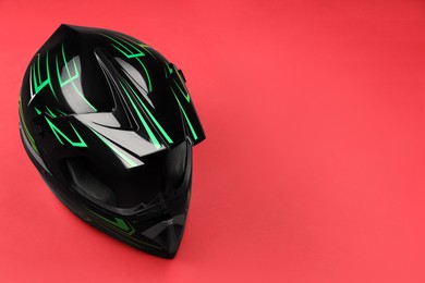 Photo of Modern motorcycle helmet with visor on red background. Space for text