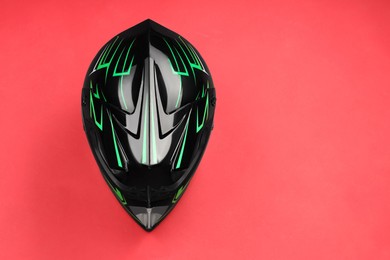 Photo of Modern motorcycle helmet with visor on red background, top view. Space for text