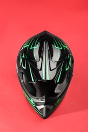 Photo of Modern motorcycle helmet with visor on red background, top view