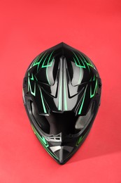 Modern motorcycle helmet with visor on red background, top view