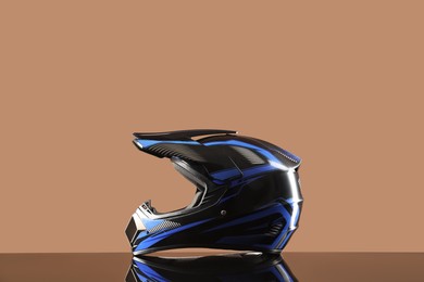 Photo of Modern motorcycle helmet with visor on mirror surface against beige background. Space for text