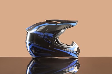 Photo of Modern motorcycle helmet with visor on mirror surface against beige background