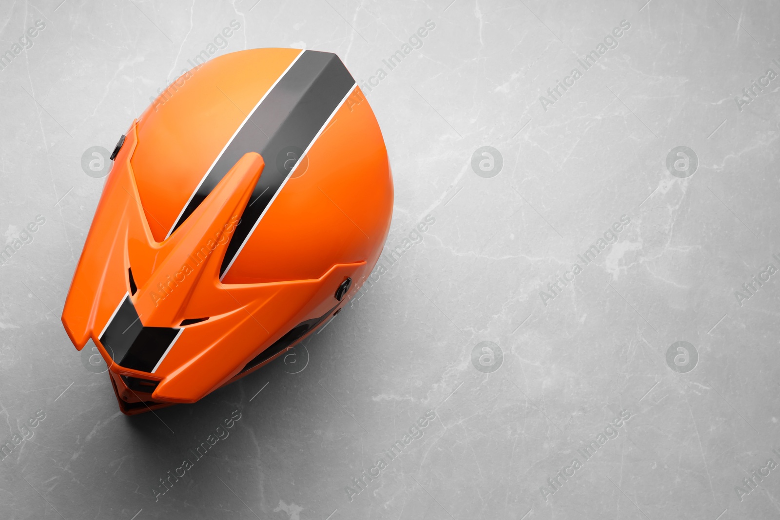 Photo of Modern motorcycle helmet with visor on light grey surface, top view. Space for text