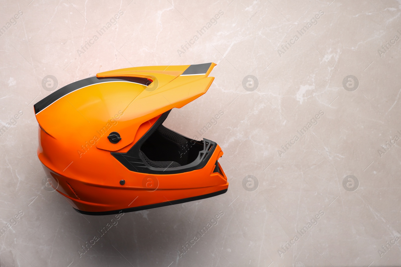 Photo of Modern motorcycle helmet with visor on light grey surface, top view. Space for text