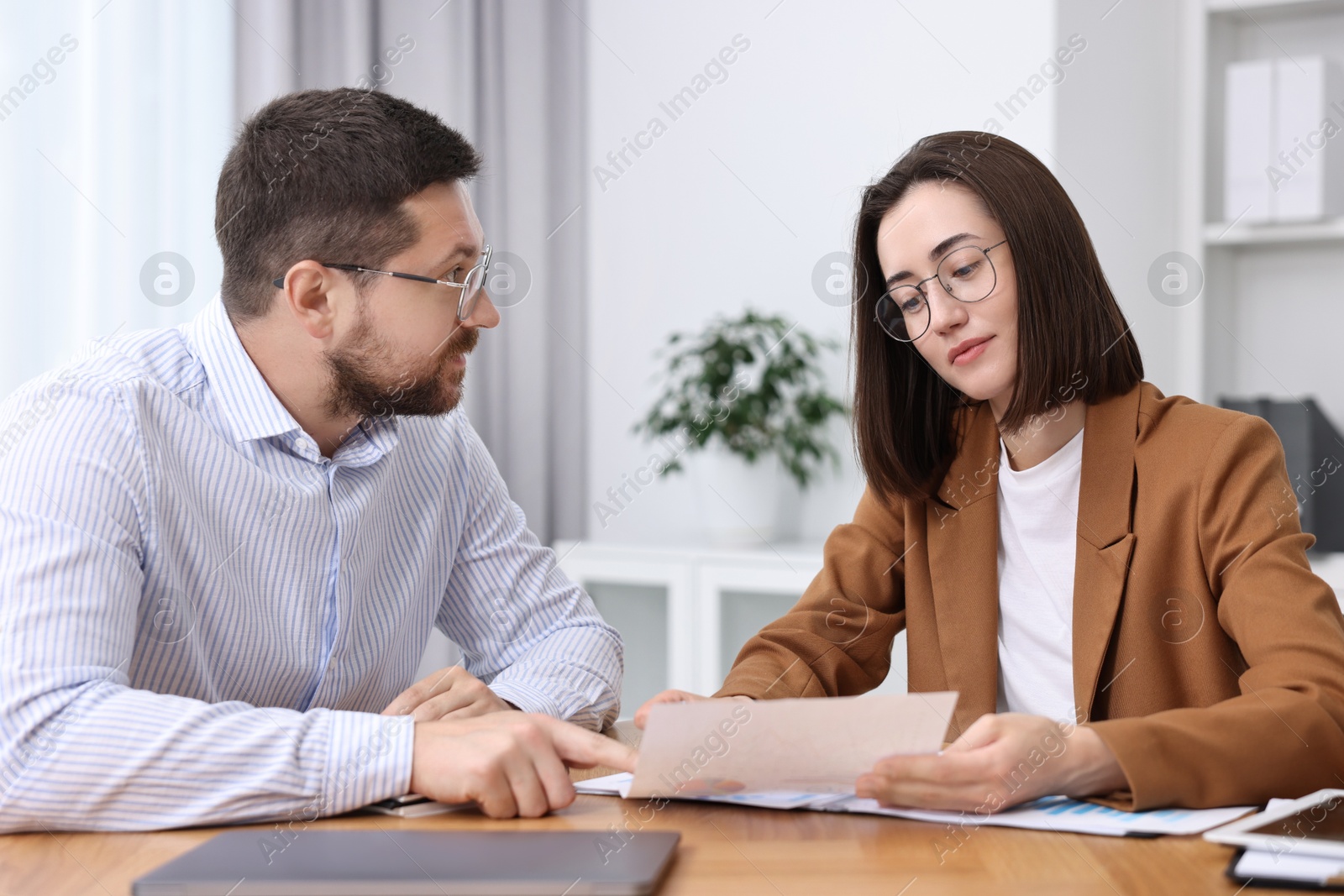 Photo of Consultant working with client at table in office