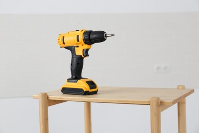 Cordless electric screwdriver on wooden table indoors