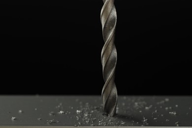 Photo of Drilling hole in grey surface on black background, closeup