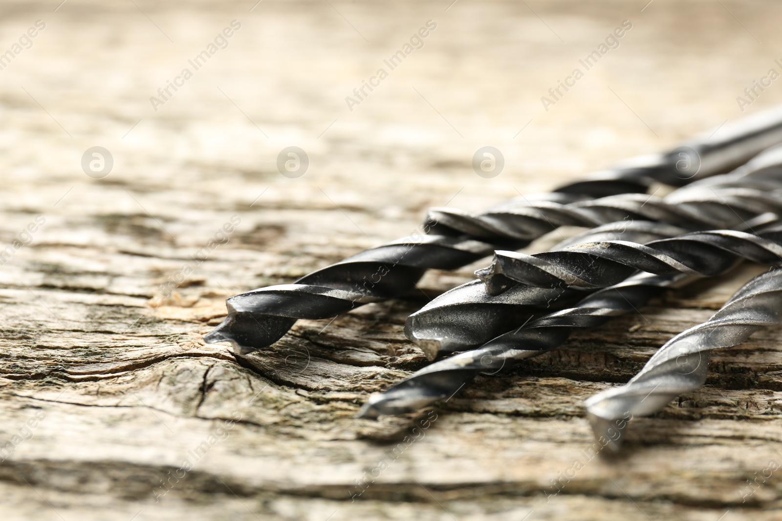 Photo of Many drill bits on wooden table, closeup