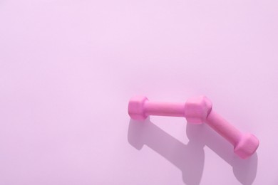 Photo of Two dumbbells on violet background, top view. Space for text