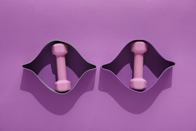 Photo of Dumbbells and fitness elastic bands on purple background, flat lay