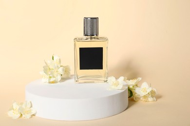 Photo of Presentation of aromatic perfume in bottle and beautiful jasmine flowers against beige background