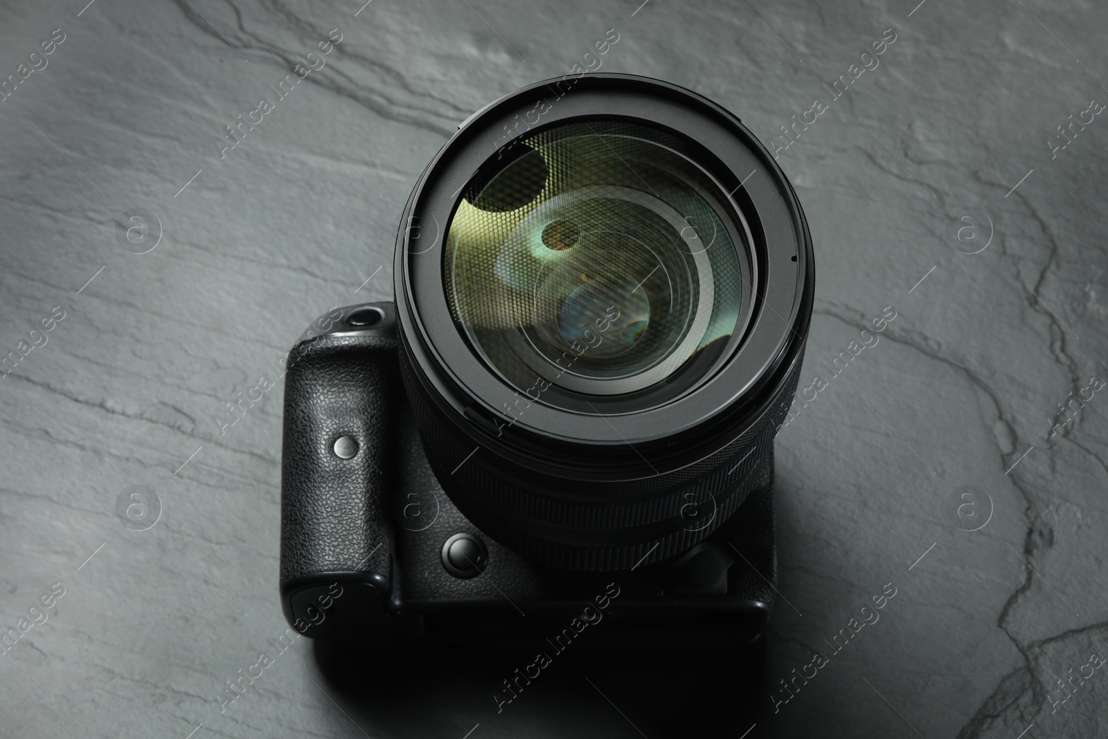 Photo of Modern photo camera on black table, above view