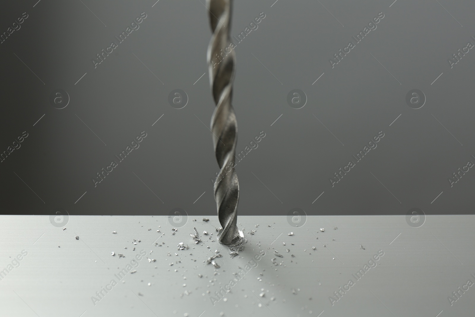 Photo of Drilling hole in light surface on gray background, closeup