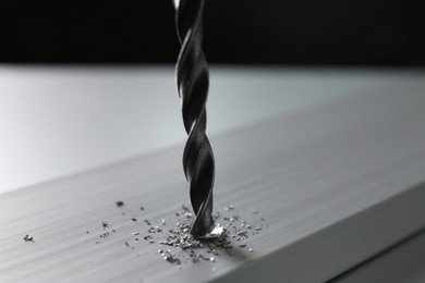 Photo of Drilling hole in plank on light table, closeup