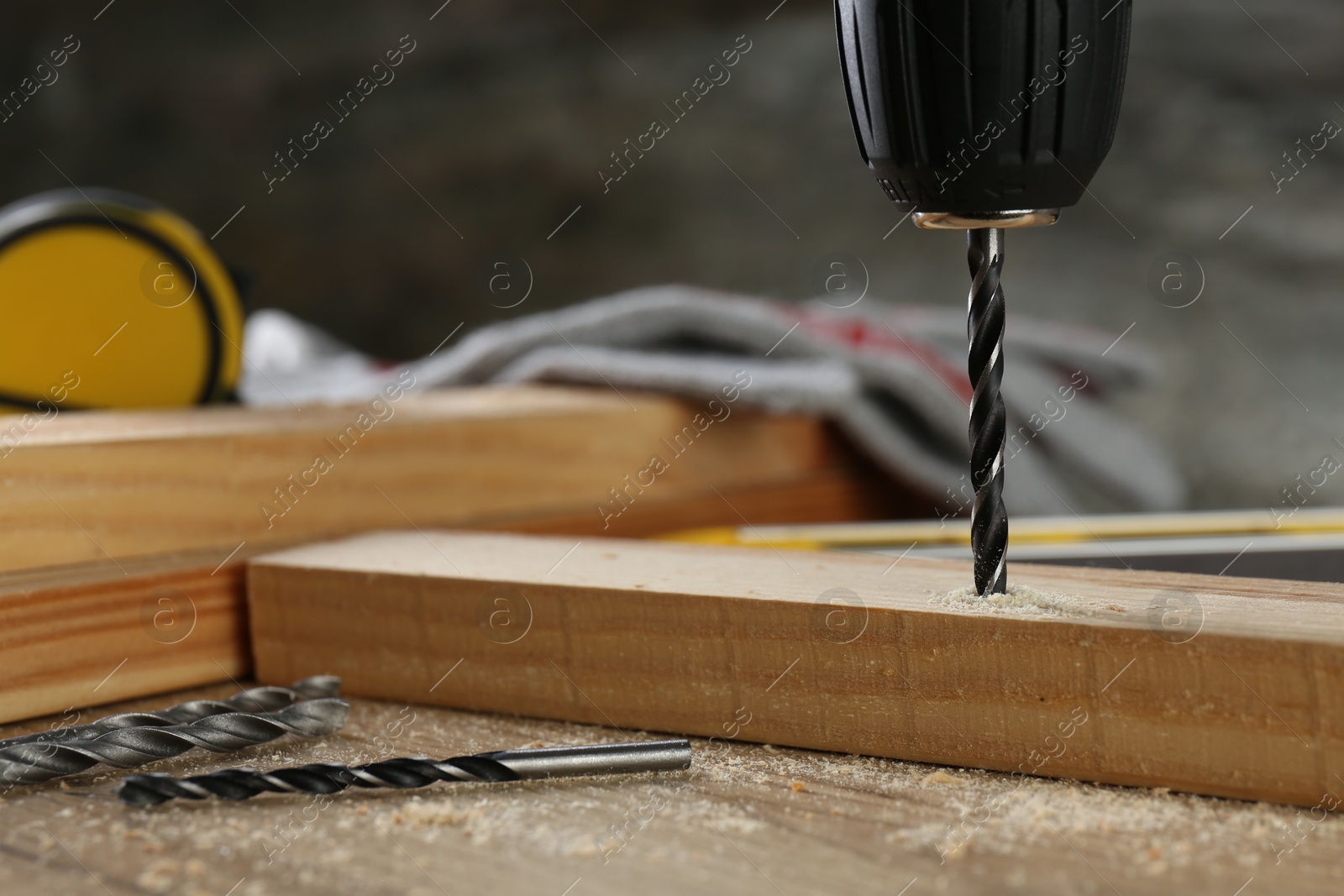 Photo of Drilling hole in plank on wooden table, closeup