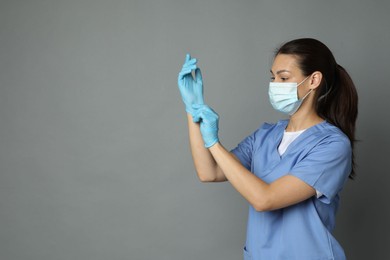 Photo of Portrait of nurse in medical mask and gloves on grey background. Space for text