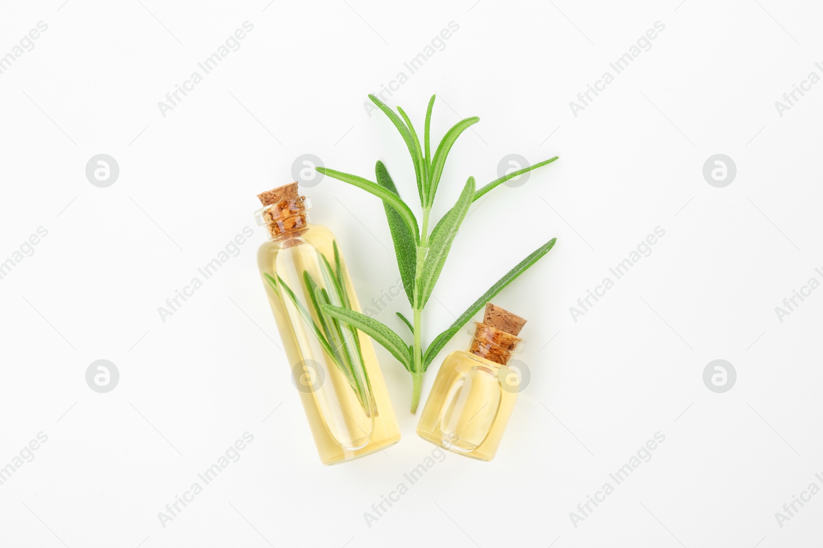 Photo of Aromatic essential oils in bottles and rosemary on white background, flat lay