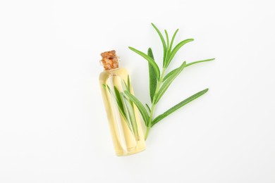 Photo of Aromatic essential oil in bottle and rosemary on white background, top view