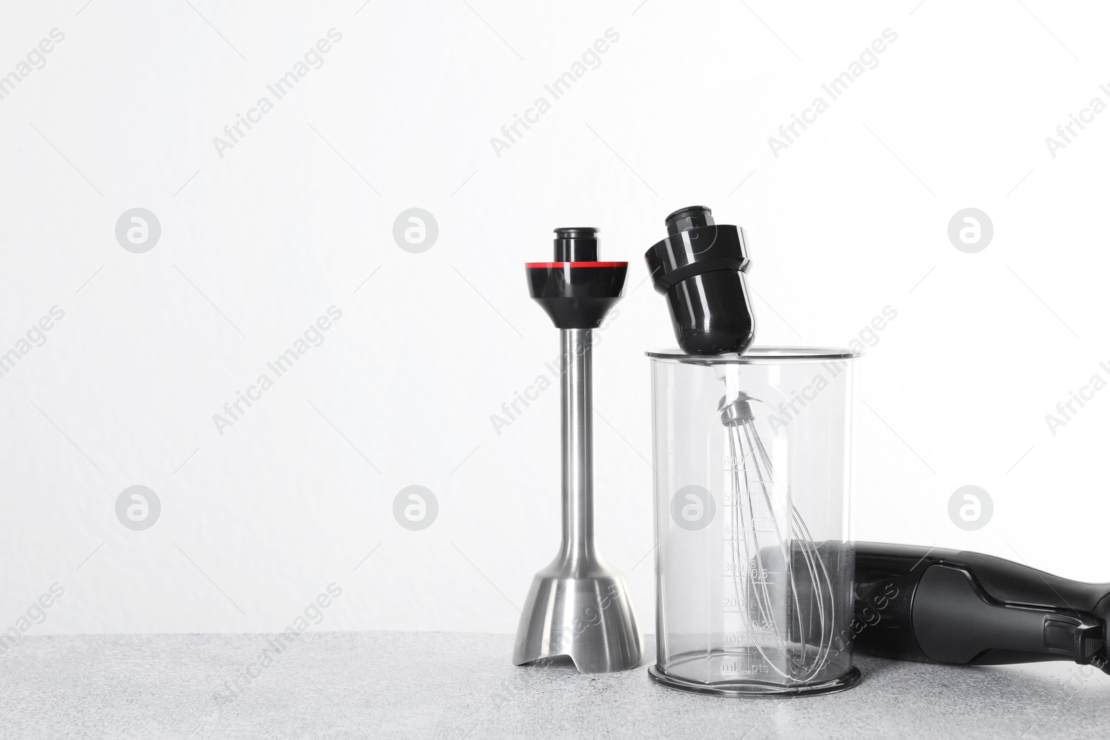 Photo of Hand blender kit on gray table against white background, space for text