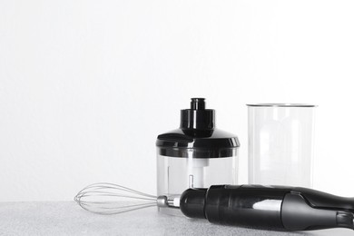 Photo of Hand blender kit on gray table against white background, space for text