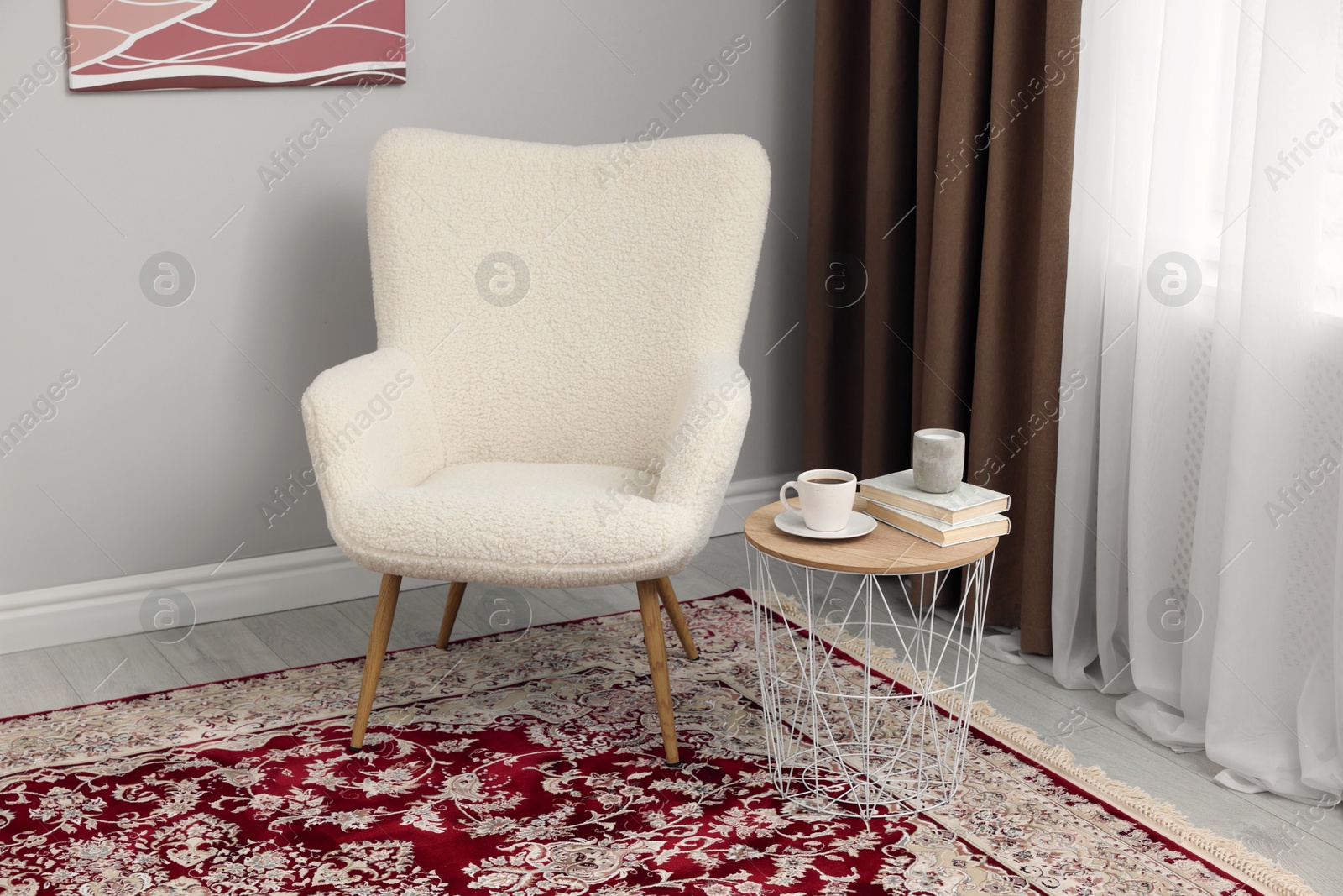 Photo of Soft armchair, side table and window with curtains indoors. Interior design