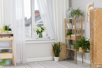 Photo of Window with beautiful curtains, houseplants and furniture in room. Interior design