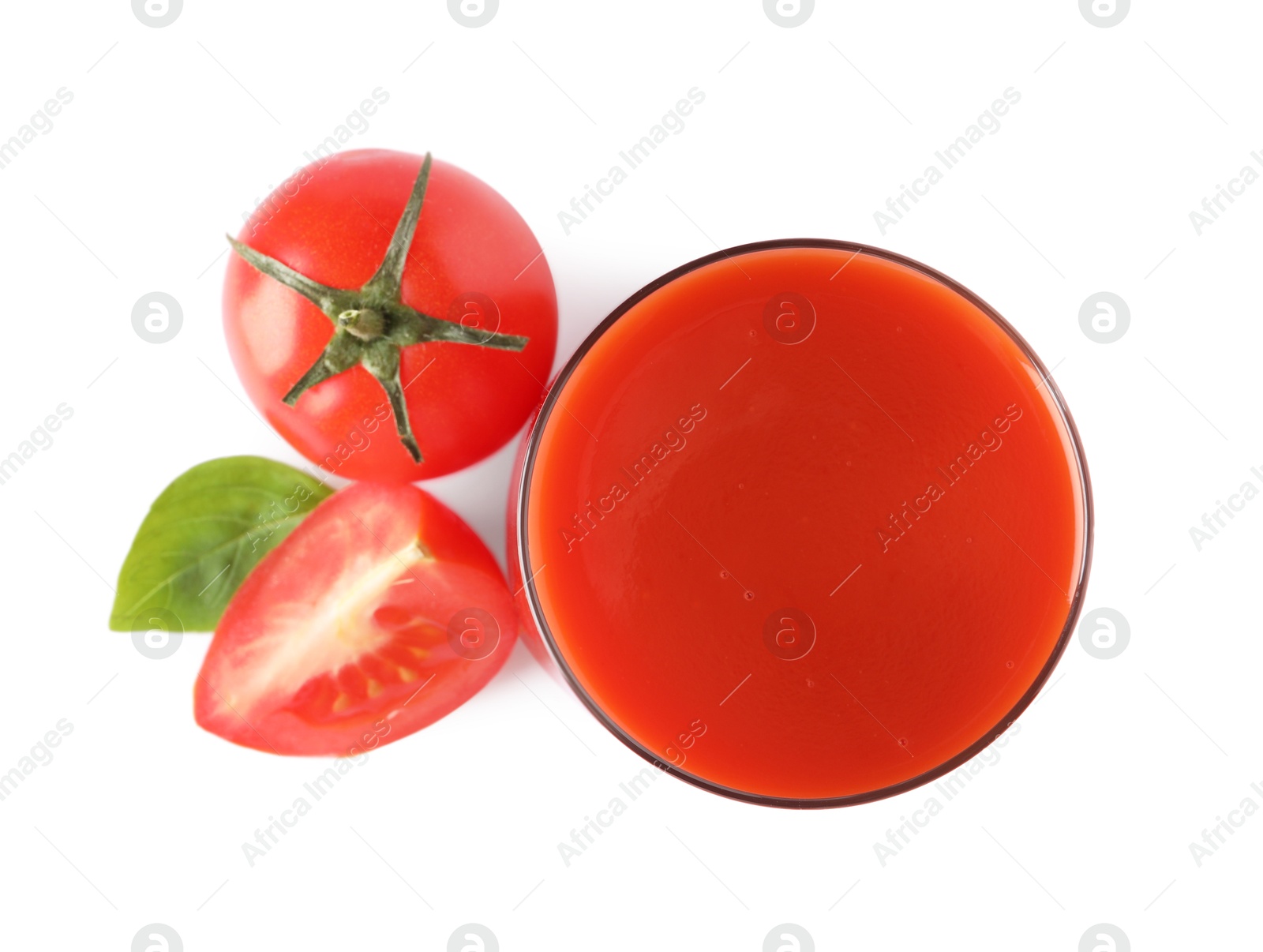 Photo of Tasty tomato juice in glass, basil and fresh vegetables isolated on white, top view