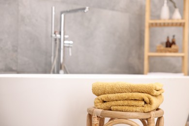 Photo of Stack of clean towels on table in bathroom, space for text