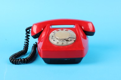 Photo of Red telephone with handset on light blue background