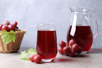 Ripe grapes and tasty juice on grey table