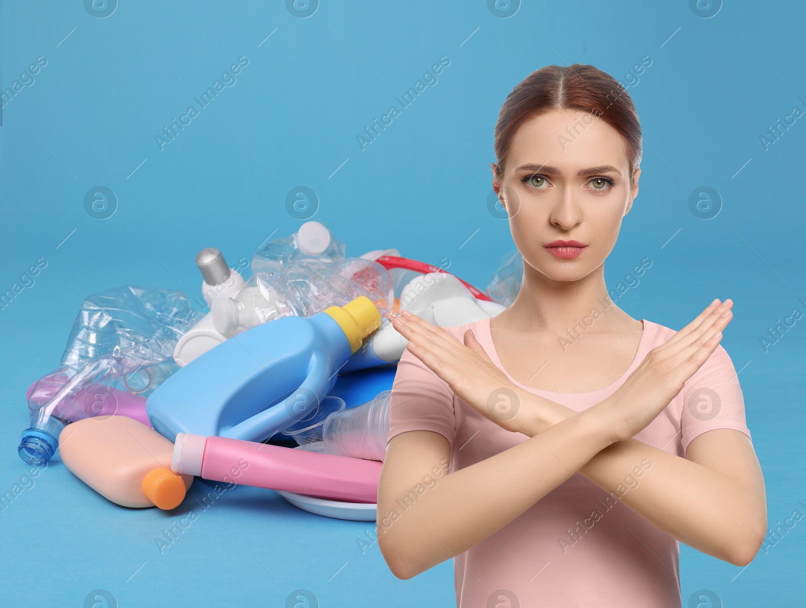 Image of Environmental pollution. Woman showing stop gesture, heap of garbage on light blue background