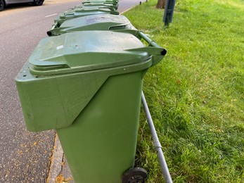 Photo of Many green trash bins on city street