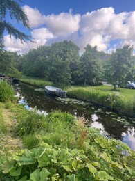 Photo of Picturesque view of river, trees and moored boats