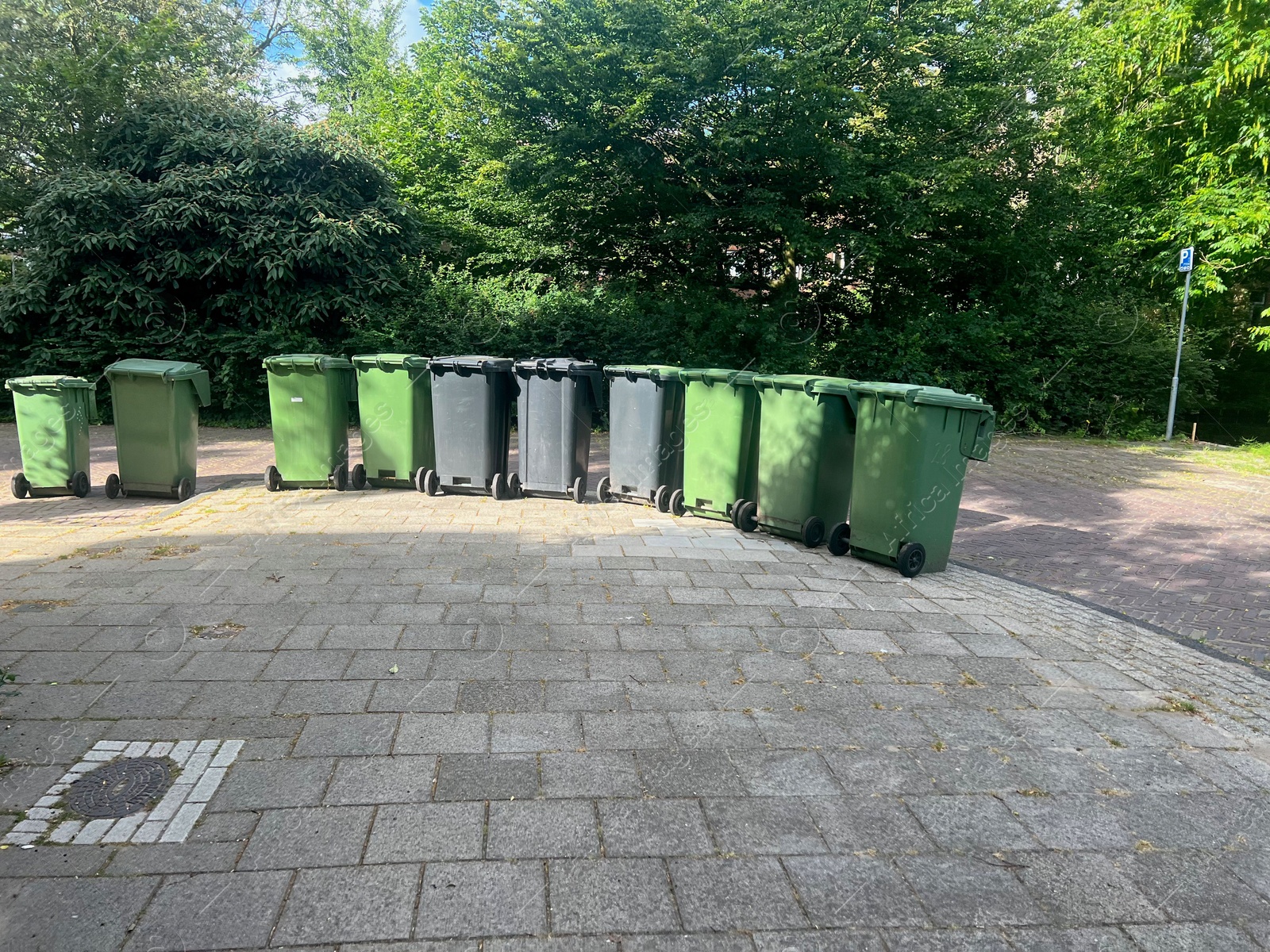 Photo of Many green trash bins on city street