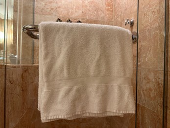 Photo of Soft terry towel hanging in hotel bathroom