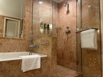 Photo of Luxury hotel interior. Stylish bathroom with mirror and terry towels