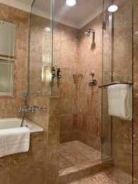 Photo of Luxury hotel interior. Stylish bathroom with mirror and terry towels