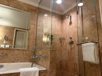 Photo of Luxury hotel interior. Stylish bathroom with mirror and terry towels