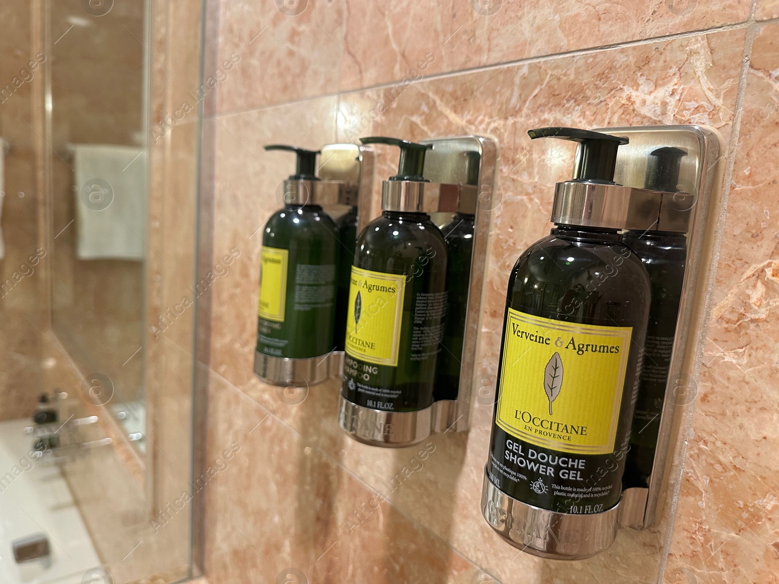 Photo of Berlin, Germany - July 2, 2024: Bottles with body care products on tiled wall in Regent Berlin Hotel bathroom