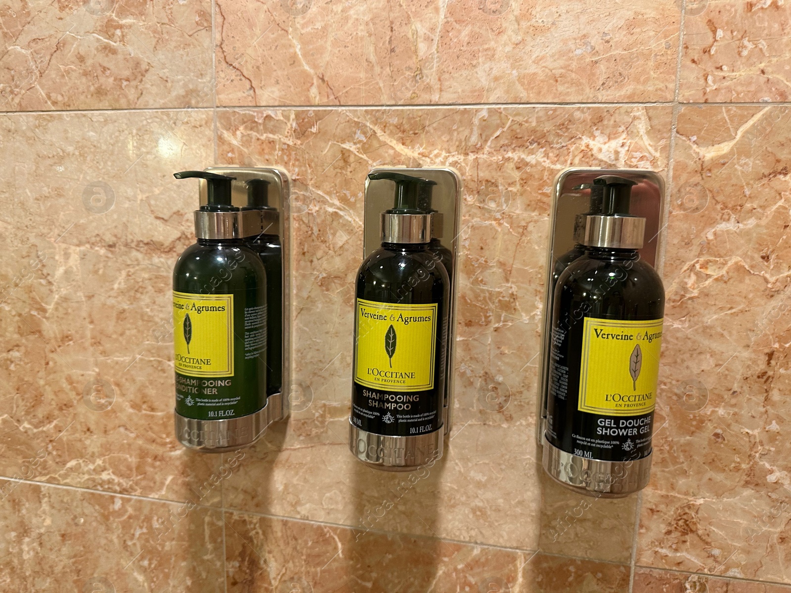 Photo of Berlin, Germany - July 2, 2024: Bottles with body care products on tiled wall in Regent Berlin Hotel bathroom