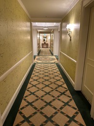 Luxury hotel interior. Empty long corridor with carpet